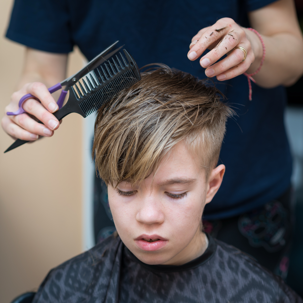 Happy child getting a kids haircut at Salon LáShae in Kannapolis, NC
